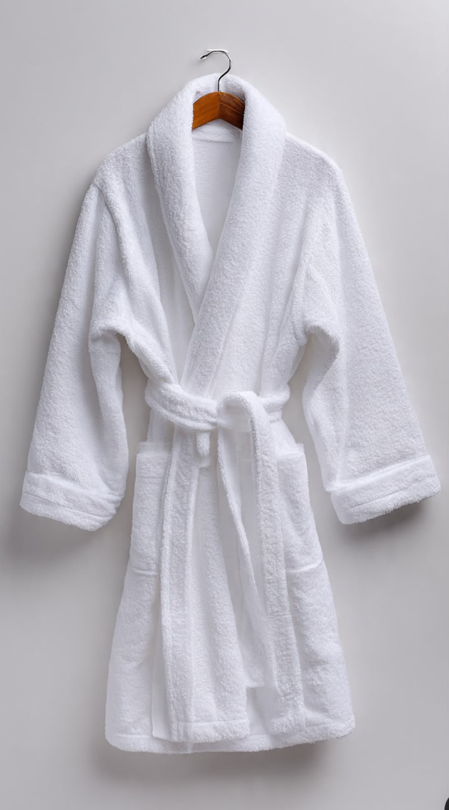 White terry bath robe on wooden hanger
